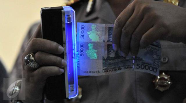 Polres Jakarta Barat merilis uang palsu, Jakarta, Jumat (25/9/2015). Tersangka dan barang bukti alat pencetak uang palsu berhasil diamankan petugas. @Liputan6.com/Gempur M Surya